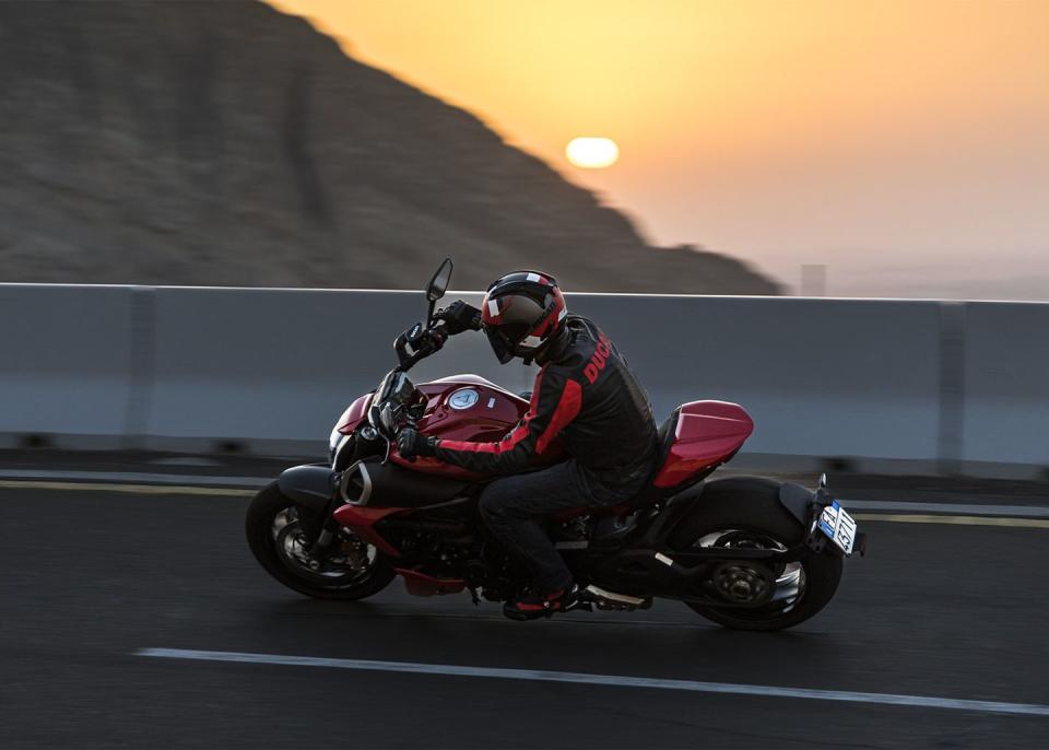 a person riding a motorcycle at sunset