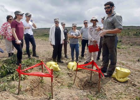 Mines Advisory Group (MAG) Vietnam's technician Daniel Dobb (R) shows U.S. Under Secretary of State for Arms Control and International Security Rose Gottemoeller (C) B-bombs marked spots during a field trip in Vietnam's central Quang Tri province, March 2, 2015. REUTERS/Kham