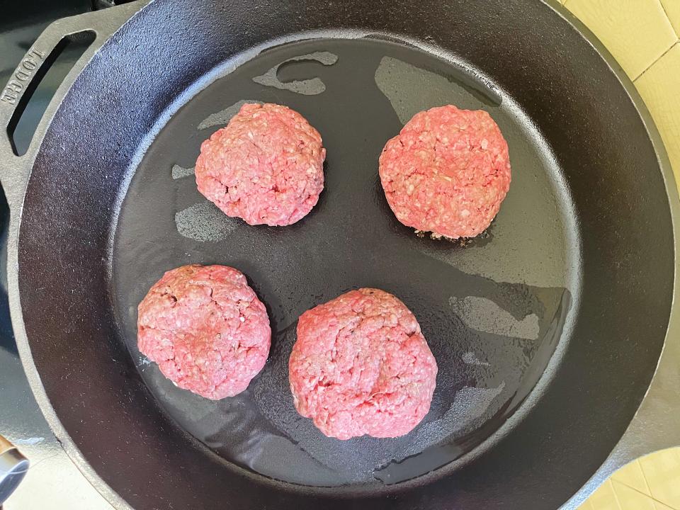 burger patties in a cast iron skillet