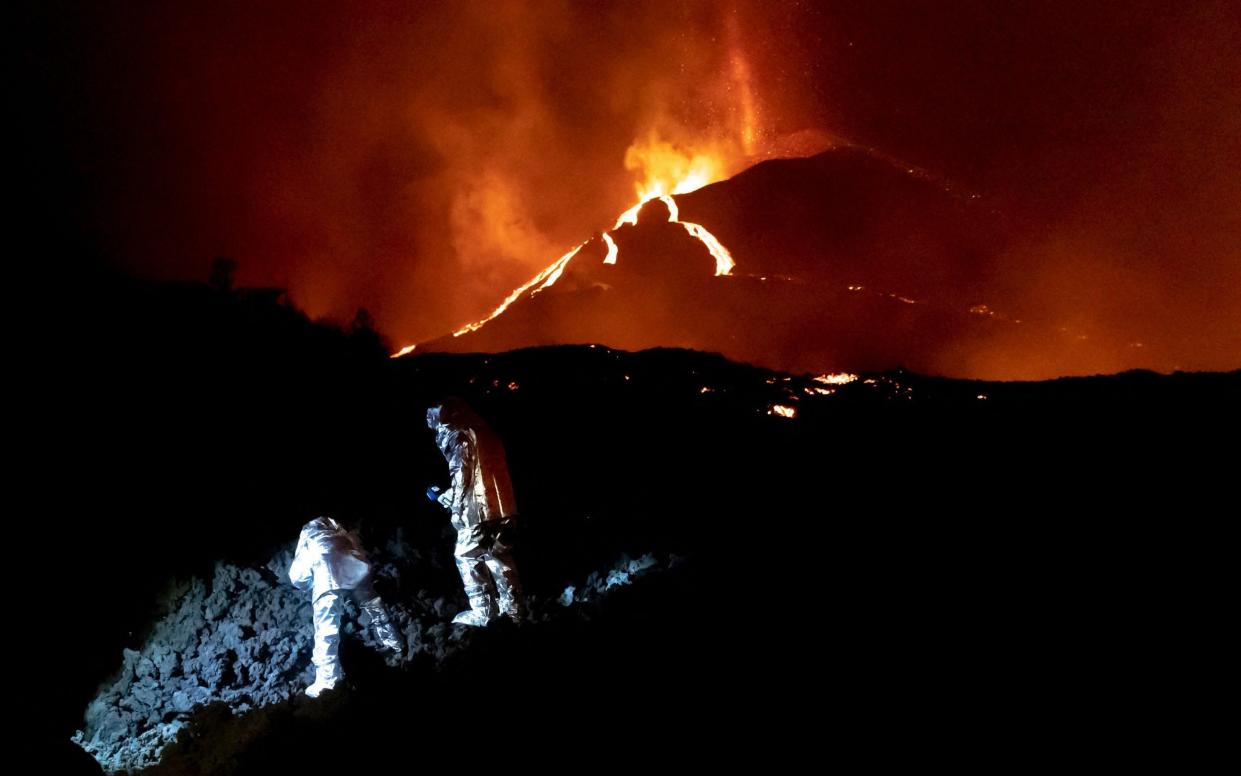 Scientists monitor the evolution of a new lava flow, following the eruption of the Cumbre Vieja volcano - AFP