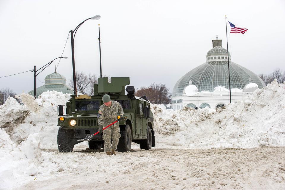 Sgt. Marshall Cashman with the 105th Military Police Company helps remove snow in South Buffalo, New York November 22, 2014. As temperatures near Buffalo, New York, rose above freezing on Saturday, volunteers fanned out to help their neighbors clear the walls of snow that have paralyzed parts of the region this week, but the warming trend also raised the threat of flooding. REUTERS/Aaron Ingrao (UNITED STATES - Tags: ENVIRONMENT)