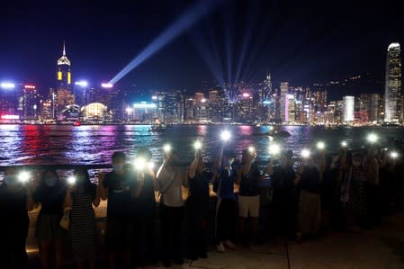 Protesters hold hands to form a human chain during a rally to call for political reforms at the Avenue of Stars in Hong Kong