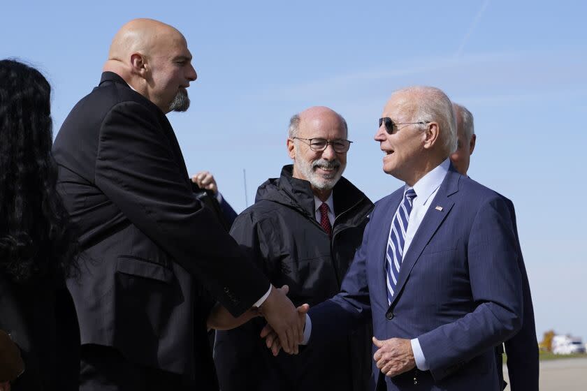 President Joe Biden speaks with Pennsylvania Lt. Gov. John Fetterman, a Democratic candidate for U.S. Senate, after stepping off Air Force One, Thursday, Oct. 20, 2022, at the 171st Air Refueling Wing at Pittsburgh International Airport in Coraopolis, Pa. Biden is visiting Pittsburgh to promote his infrastructure agenda. (AP Photo/Patrick Semansky)