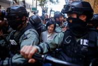 Police escort senior pro-establishment lawmaker Regina Ip after she turned up at an anti-government protest in the Central district of Hong Kong