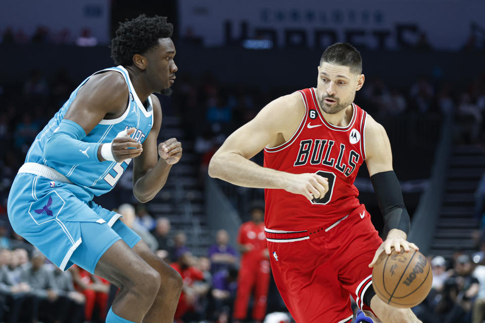 Chicago Bulls center Nikola Vucevic, right, drives against Charlotte Hornets center Mark Williams during the first half of an NBA basketball game in Charlotte, N.C., Friday, March 31, 2023. (AP Photo/Nell Redmond)