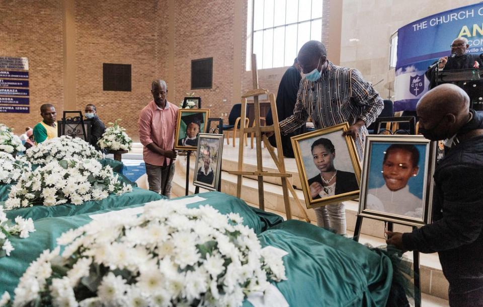 Photos are placed at the funeral service for the Jileka family, a single family who drowned when their home was engulfed in water following devastating floods in Kwa-Zulu Natal province (AFP via Getty Images)