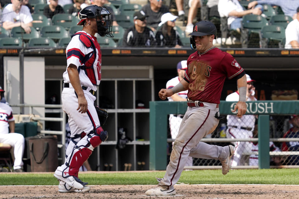 Arizona Diamondbacks' Daulton Varsho, right, scores on a one-run double by Jake McCarthy as Chicago White Sox catcher Seby Zavala looks to the field during the ninth inning of a baseball game in Chicago, Sunday, Aug. 28, 2022. The Diamondbacks won 3-2. (AP Photo/Nam Y. Huh)