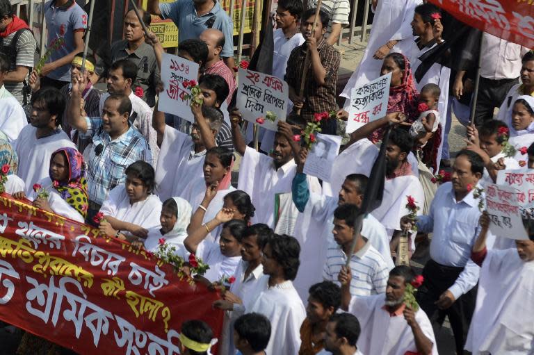 Bangladeshi activists and relatives of the victims of the Rana Plaza building collapse wear funeral shrouds as they take part in a protest marking the first anniversary of the disaster in Savar, on the outskirts of Dhaka, on April 24, 2014