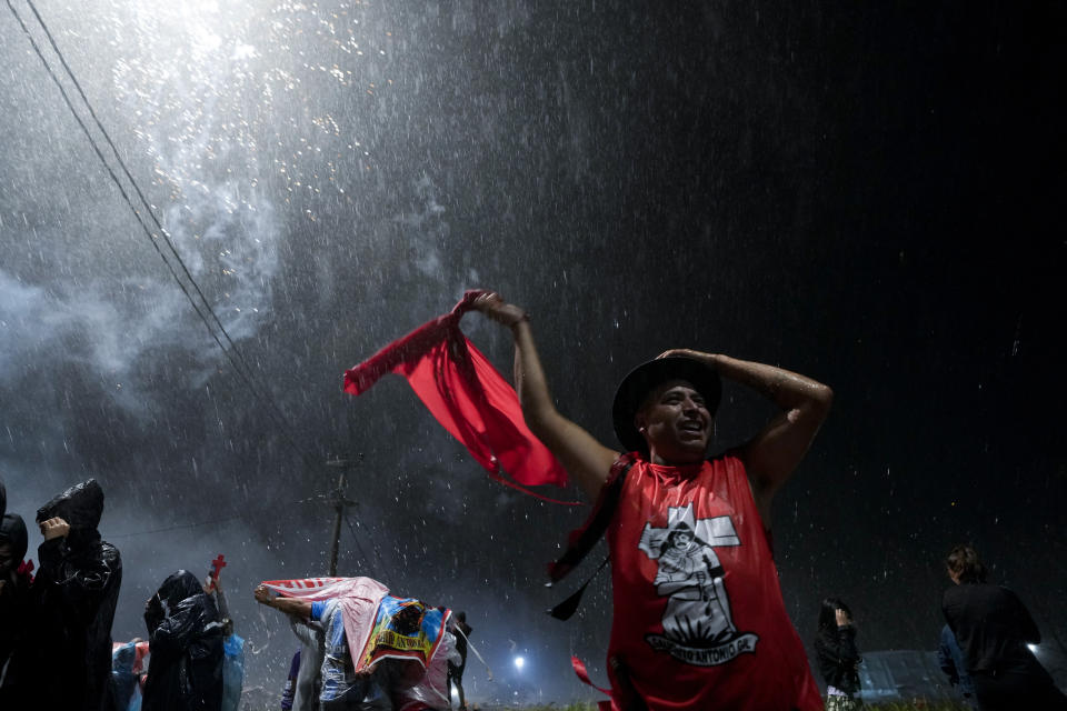 A man walks under the pouring rain outside the sanctuary of Argentina's folk Saint "Gauchito" Gil in Mercedes, Corrientes, Argentina, Sunday, Jan. 7, 2024. Every Jan. 8, devotees from across the country visit his sanctuary to ask for miracles or give him thanks.(AP Photo/Natacha Pisarenko)