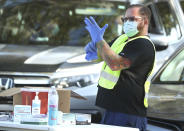 Health care professionals administer the COVID-19 vaccine at Lake-Sumter State College in Leesburg, Fla., on Friday, Jan. 1, 2021. Long lines of cars were at the site as the Lake County vaccines are currently being given to people who are 65 years and older and front line workers. (Stephen M. Dowell /Orlando Sentinel via AP)