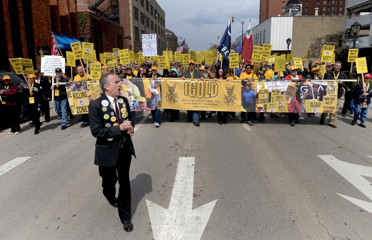Tom Shafer, of Springfield, front left, leads a crowd of marchers from the Bank of Springfield Center to the state Capital during Illinois Gun Owner Lobby Day Wednesday, March, 29, 2023.