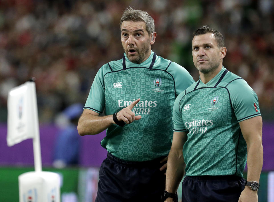 Referee Jerome Garces, left, and his assistant Karl Dickson watch a video review during the Rugby World Cup Pool D game at Oita Stadium between Wales and Fiji in Oita, Japan, Wednesday, Oct. 9, 2019. (AP Photo/Aaron Favila)