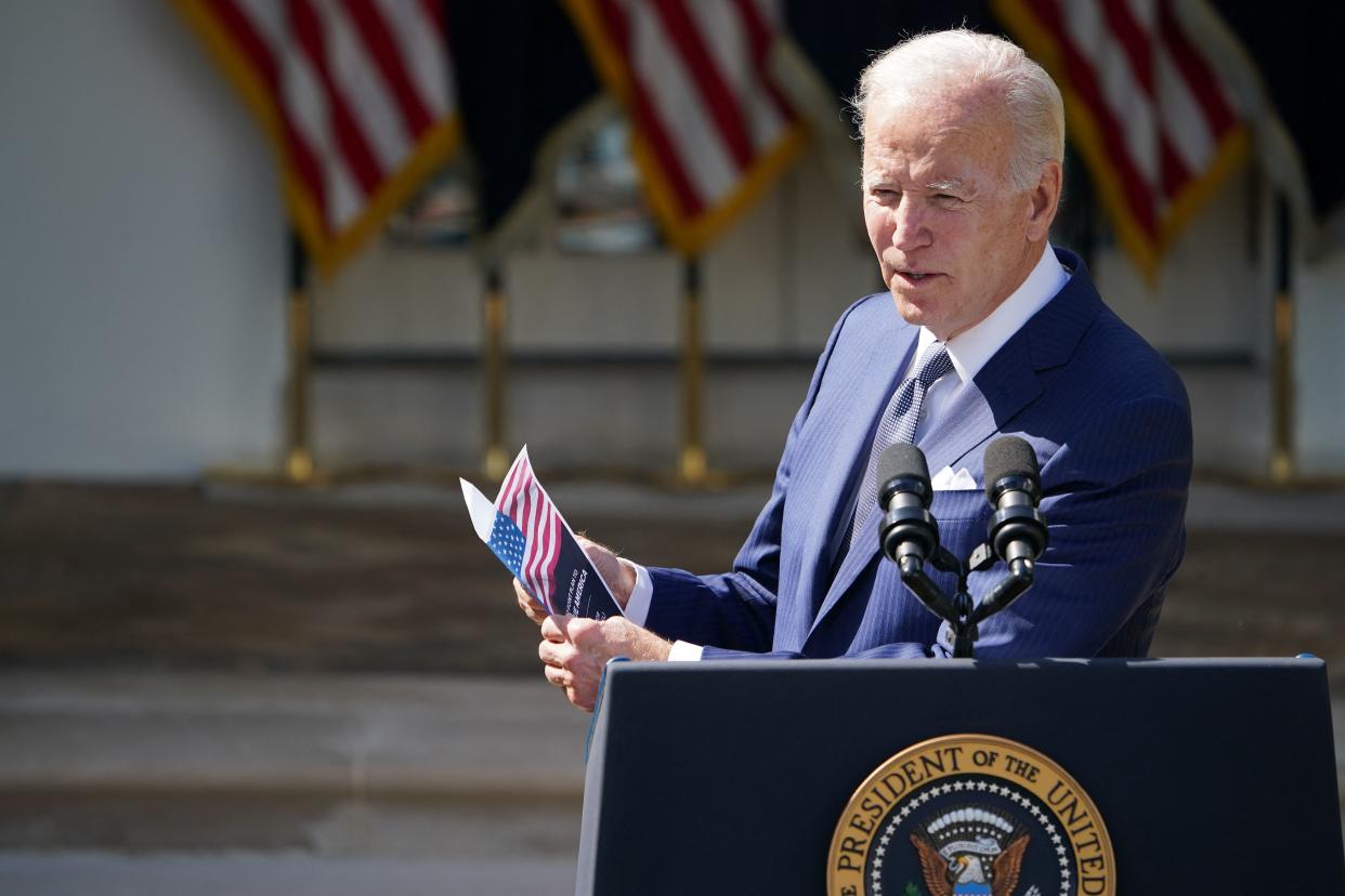 US President Joe Biden, holding a pamphlet by US Republican Senator  Scott titled 