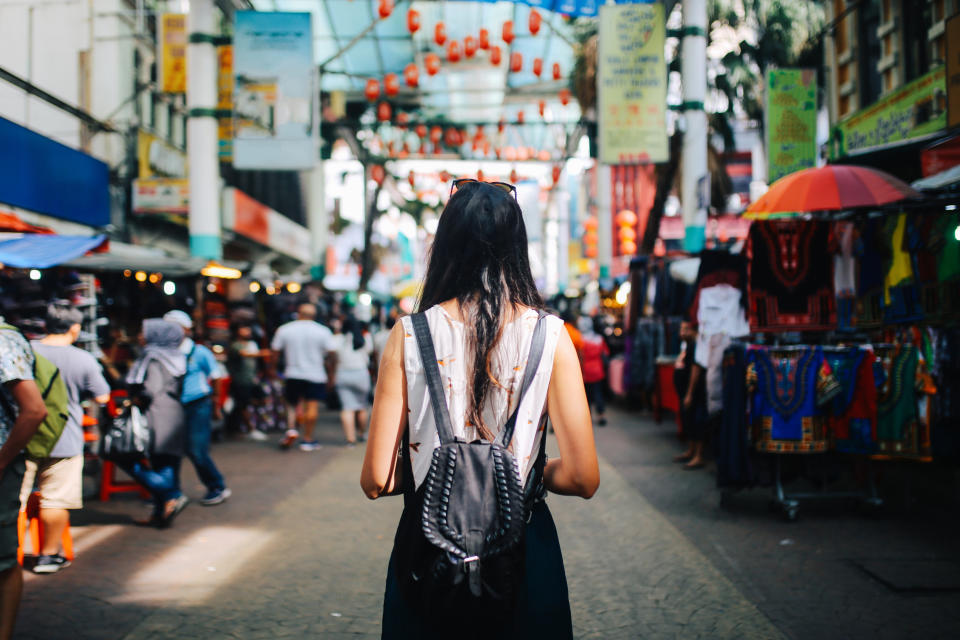 Young traveler woman walking through the stalls in Chinatown district of Kuala Lumpur, Malaysia.