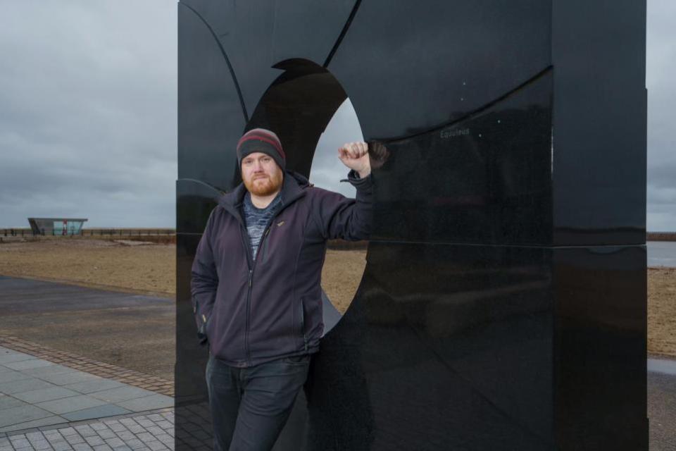 The Northern Echo: University of Sunderland engineering student John Race at the 'C' sculpture on Roker seafront, commemorating the place where the Venerable Bede calculated the motion of the sun and the moon to help set the date of Easter