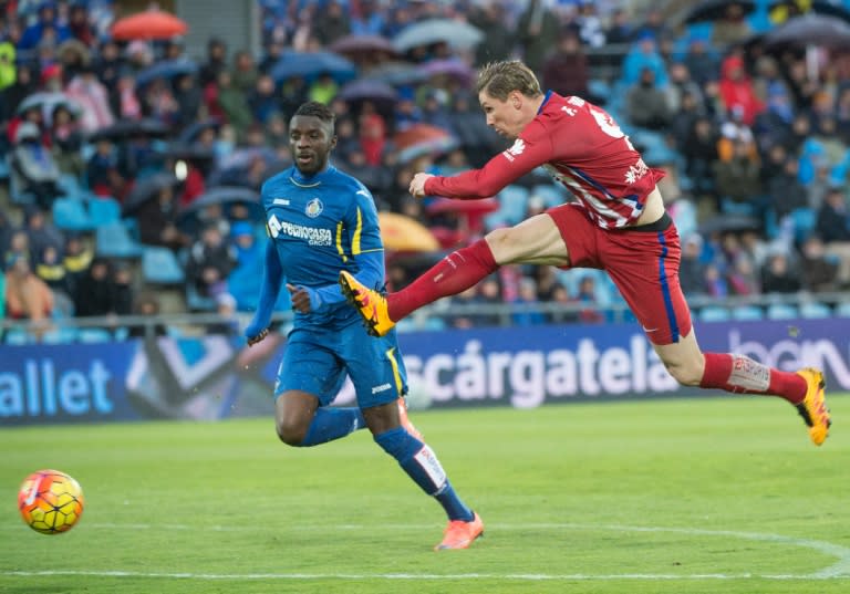 Atletico Madrid's forward Fernando Torres (R) kicks the ball next to Getafe's midfielder Karim Abdoul Yoda during a Spanish league football match on February 14, 2016