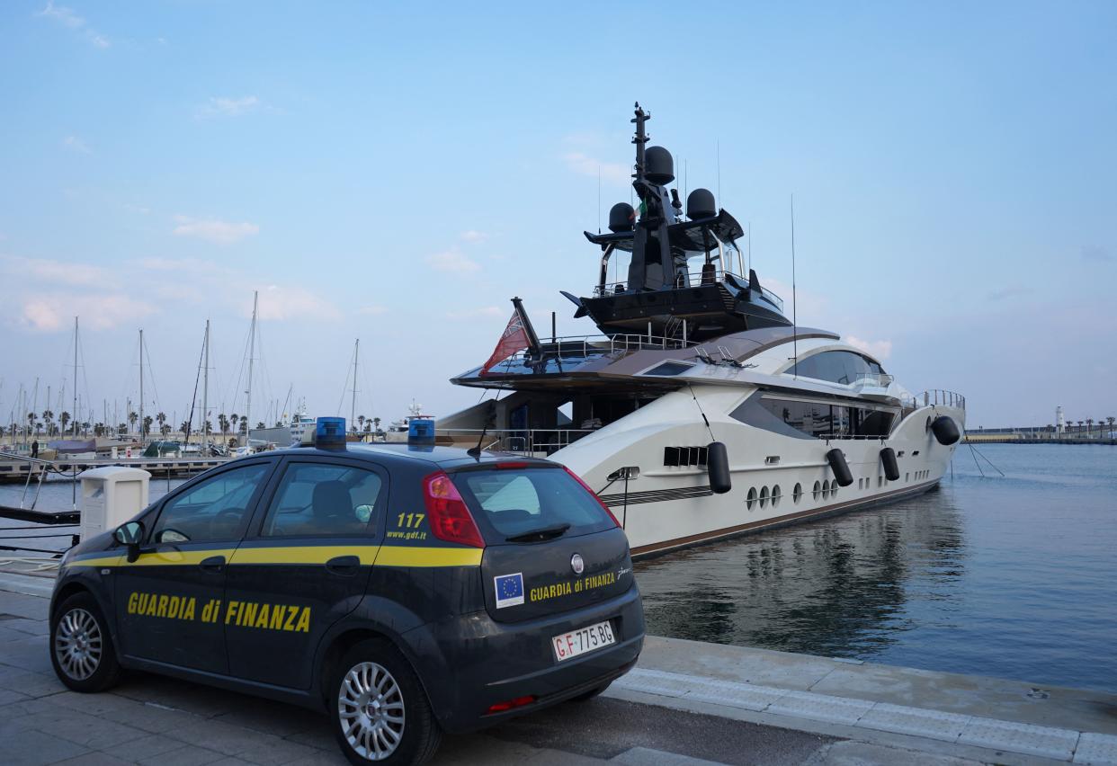 An Italian Finance Police car is parked in front of the yacht 