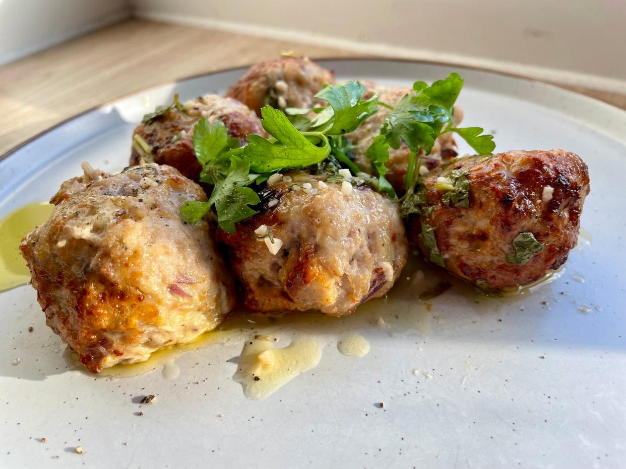 Chicken meatballs with a garnish on a plate.