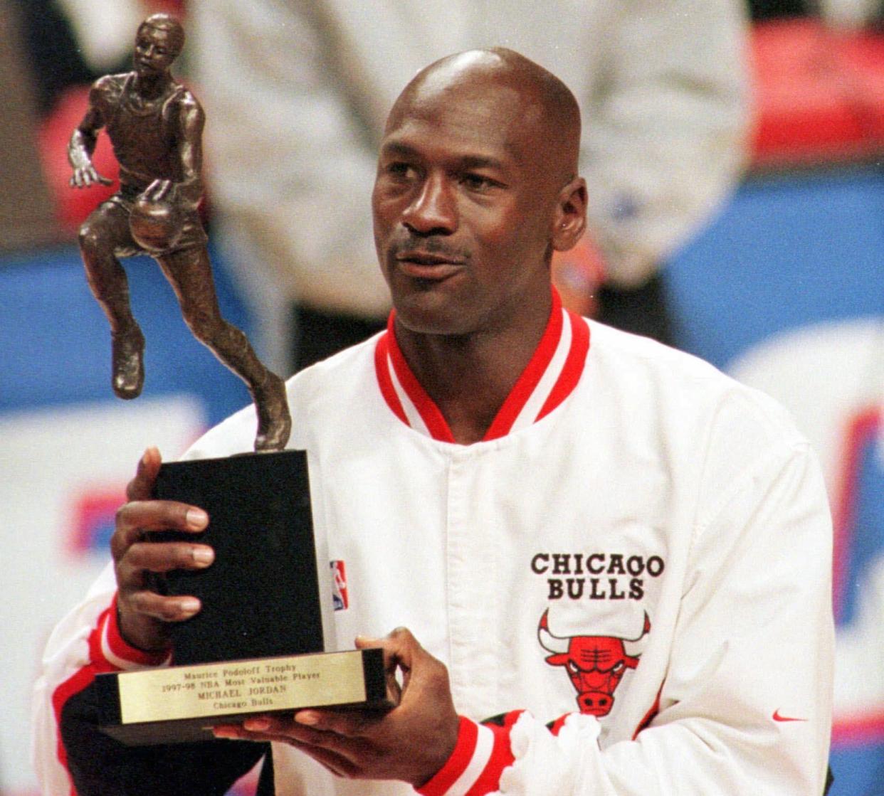 Chicago Bulls' Michael Jordan looks at the MVP award presented to him before the Bulls-Indiana Pacers playoff game Tuesday, May 19, 1998  in Chicago. (AP Photo/Frank Polich)