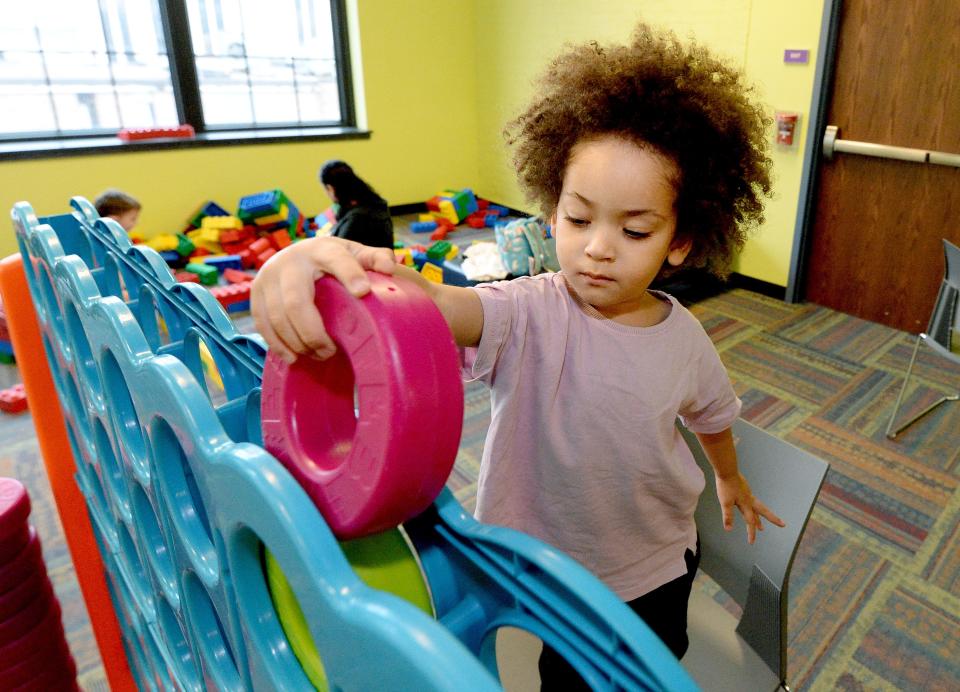 Satori Walker, 2, of London, England, plays with a game at the Kidzeum Friday, Dec. 22, 2023. Walker was with his mom, who grew up in Springfield, visiting family for the holidays.