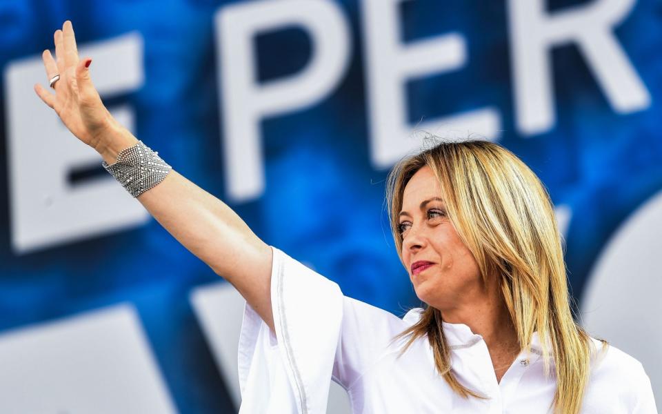 Giorgia Meloni waves at a rally of Italy's Right-wing parties in Rome in July.  - AFP