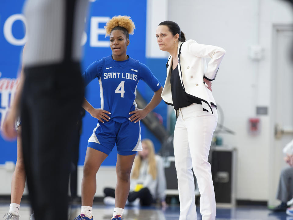 Saint Louis' Kennedy Calhoun (4) and head coach Rebecca Tillett talk during the first half of an NCAA college basketball championship game against Massachusetts in the Atlantic 10 Conference Tournament, Sunday, March 5, 2023, in Wilmington, Del. (AP Photo/Jason Minto)