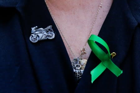FILE PHOTO: A motorcycle pin is seen on the shirt of Charlotte Charles, the mother of British teen Harry Dunn who was killed in a car crash on his motorcycle, allegedly by the wife of an American diplomat, during an interview in the Manhattan borough of Ne