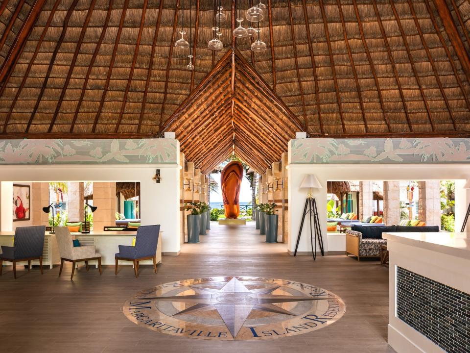 The lobby of Margaritaville Island Reserve Riviera Cancun in Mexico with a giant flip flop at the end of an open hallway