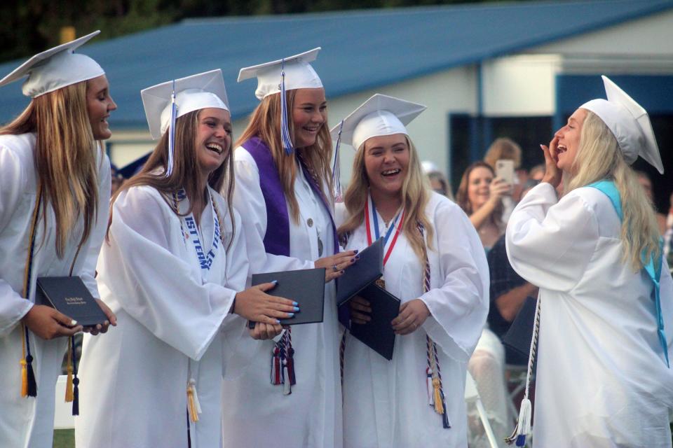 Clay High School students Abby Rutledge, Sydney Davis, Ema Martin, Gabby Wiseman and Kierstyn Mann react after receiving their diplomas during the graduation ceremony for seniors on the softball team on May 22, 2022. [Clayton Freeman/Florida Times-Union]