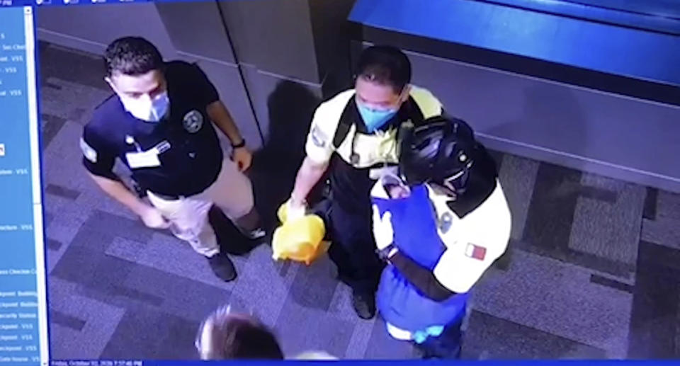 CCTV footage shows three men with masks, one man holding a newborn baby. Source: Doha News via AP