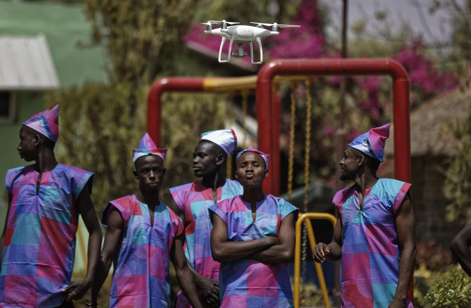 In this photo taken Monday, Feb. 18, 2019, a drone films performers as they record a music video calling for a peaceful election, at a golf resort outside of Kano, northern Nigeria. Faced with an election that could spiral into violence, some in the popular Hausa-language film industry known as Kannywood assembled this week to shoot an urgent music video appealing to the country for peace. (AP Photo/Ben Curtis)