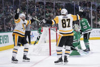 Pittsburgh Penguins center Sidney Crosby (87) and Bryan Rust (17), left, celebrate after Crosby scored against Dallas Stars goaltender Jake Oettinger (29) in the second period of an NHL hockey game, Thursday, March 23, 2023, in Dallas. (AP Photo/Tony Gutierrez)