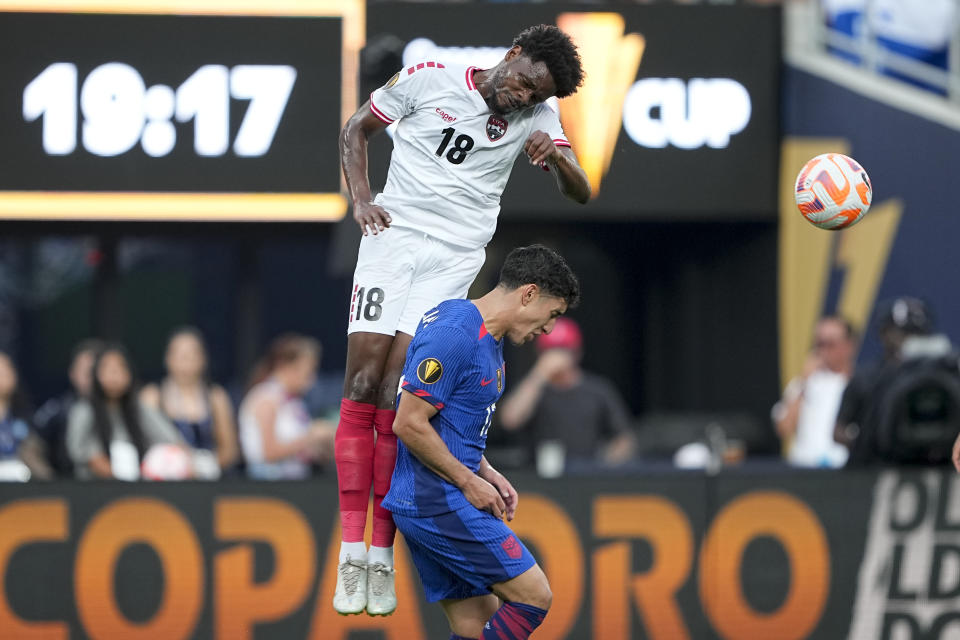 Trinidad and Tobago defender Triston Hodge heads the ball away from United States forward Alejandro Zendejas during the first half of a CONCACAF Gold Cup soccer match on Sunday, July 2, 2023, in Charlotte, N.C. (AP Photo/Chris Carlson)