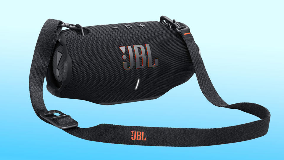 اسپیکر JBL Xtreme 4 با بند شانه ای که در پس زمینه شیب آبی و سفید دیده می شود.