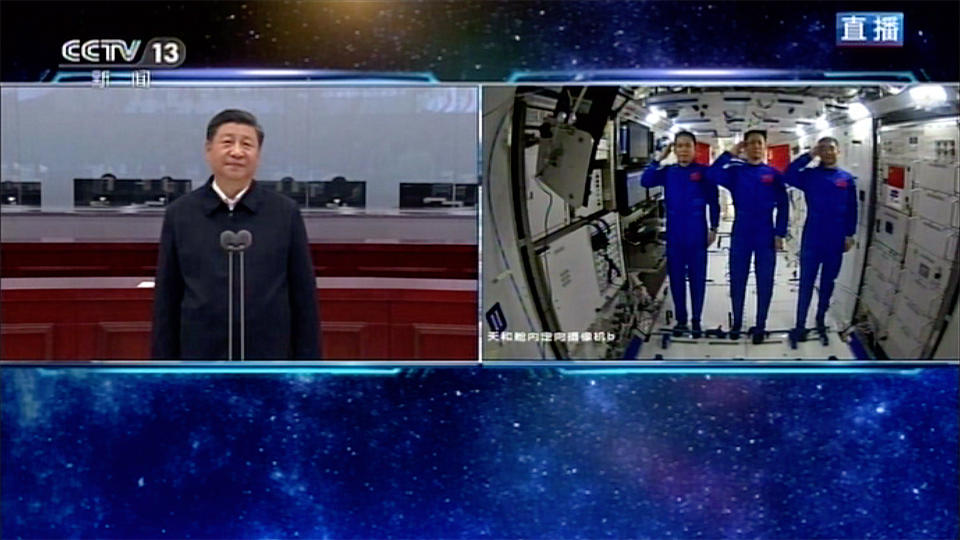 In this image taken from video footage run by China's CCTV, Chinese astronauts, right, salute as they talk with Chinese President Xi Jinping, at the China's new space station in space on Wednesday, June 23, 2021. (CCTV via AP Video)