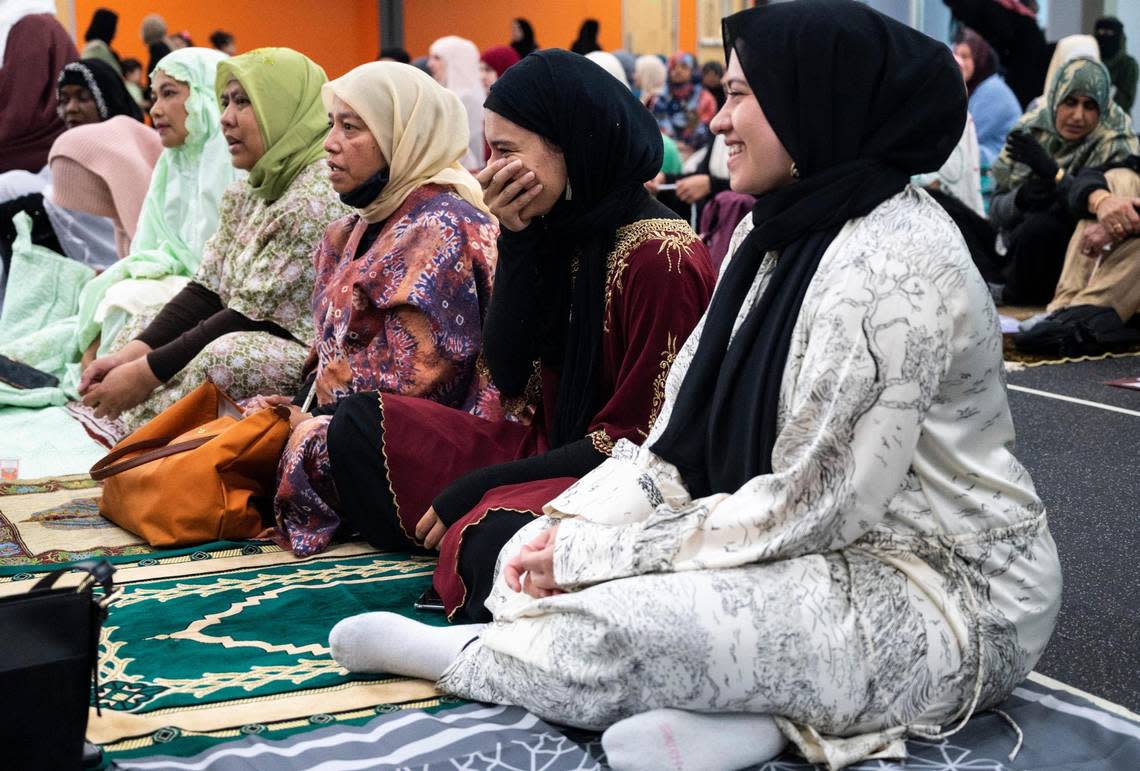 A woman holds hand over her mouth as she laughs with friend before the start of a prayer led by Imam Abdulhakim Mohammed for a celebration of the Islamic holiday, Eid al-Adha, at what will soon be the new Islamic Center on Montana Avenue in Tacoma, on Saturday, July 9, 2022.