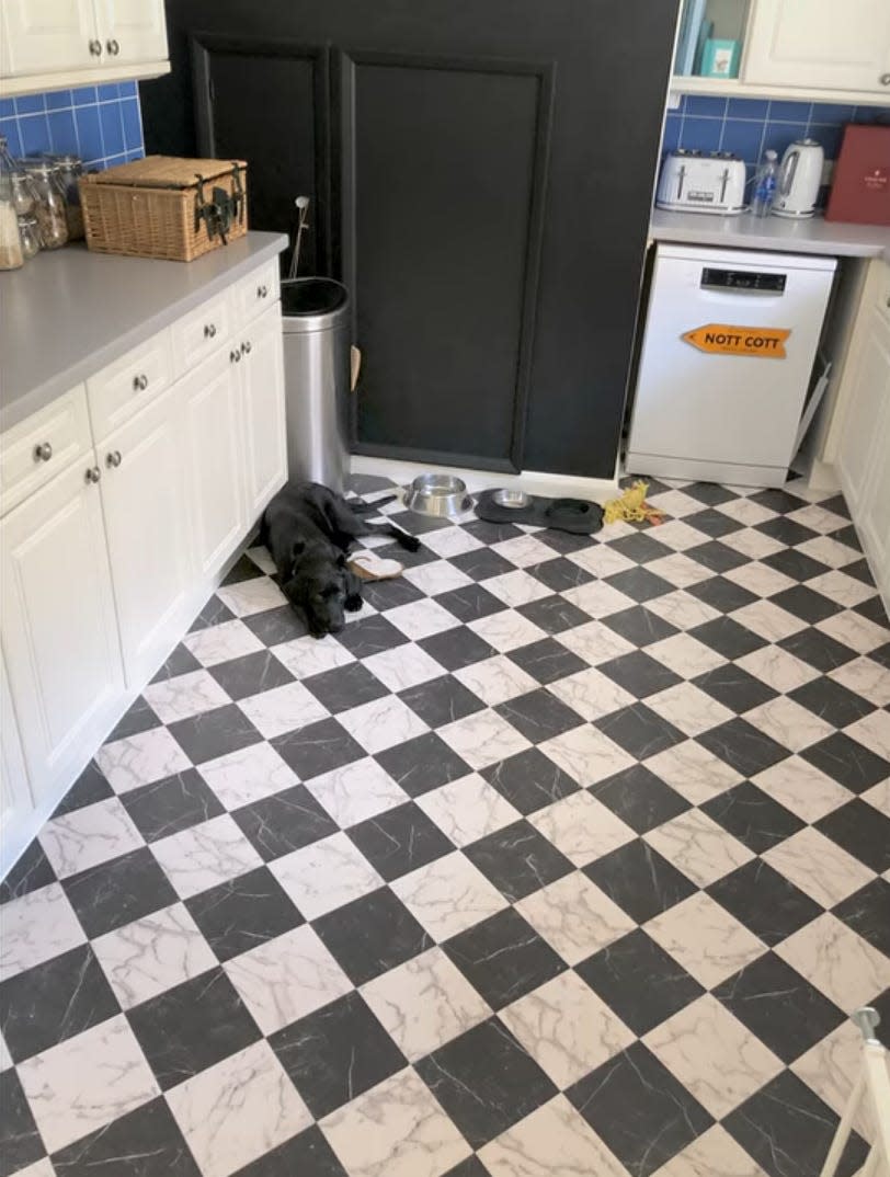 The inside of Nottingham Cottage, with a checkered floor and a black lab lying on the floor