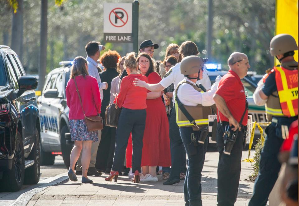 Employees are ushered away from the entrance of the Gardens Mall after a shooting there on February 14, 2024, in Palm Beach Gardens, Florida.