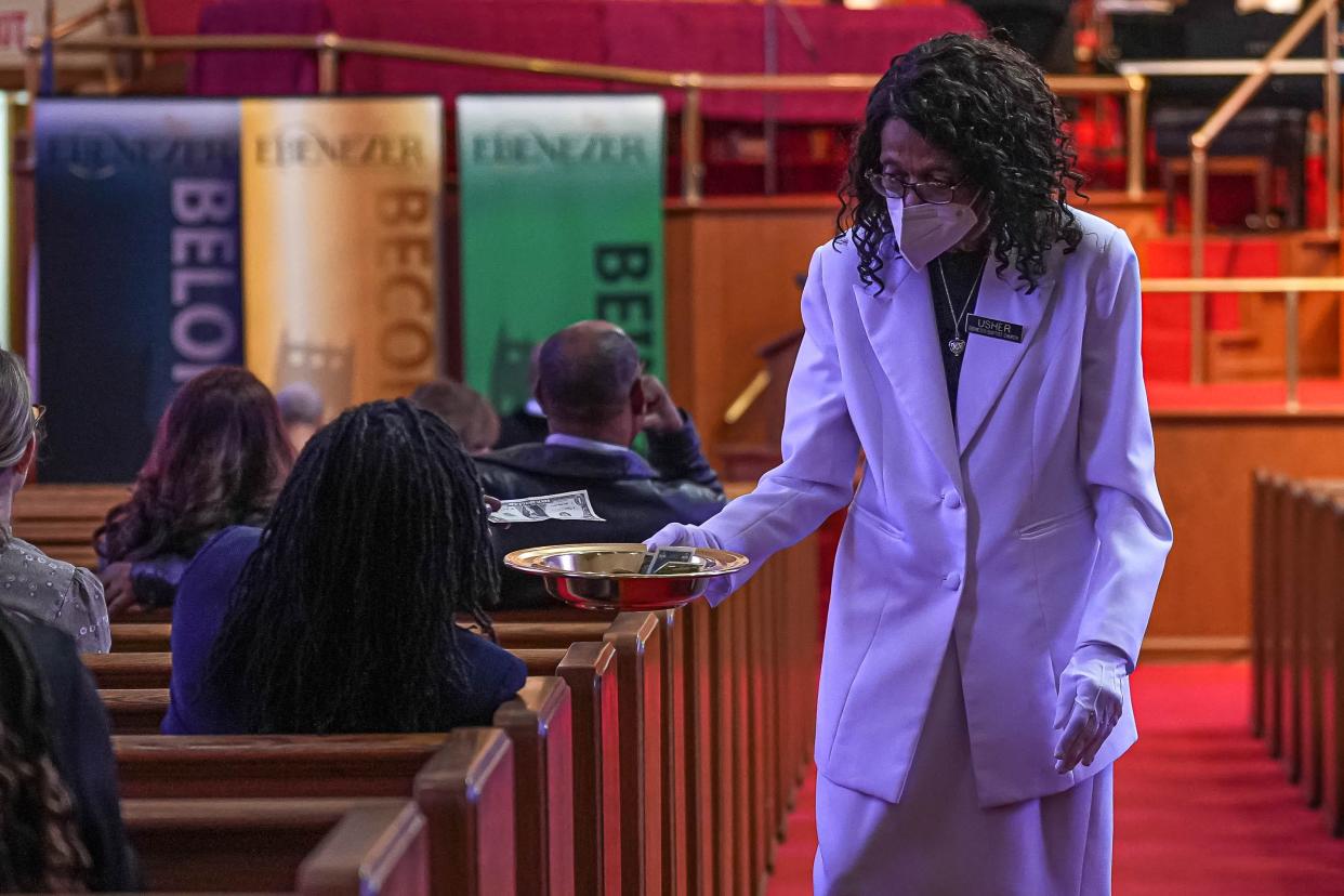 Usher Dora Glover collects offerings from the congregation at Ebenezer Third Baptist Church on April 21. The congregation was first formed in 1875.