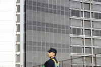 A police officer stands guard at Tokyo Detention Center, where former Nissan chairman Carlos Ghosn and another former executive Greg Kelly, are being detained, in Tokyo Friday, Dec. 21, 2018. Japanese prosecutors added a new allegation of breach of trust against Ghosn on Friday, dashing his hopes for posting bail. (AP Photo/Eugene Hoshiko)