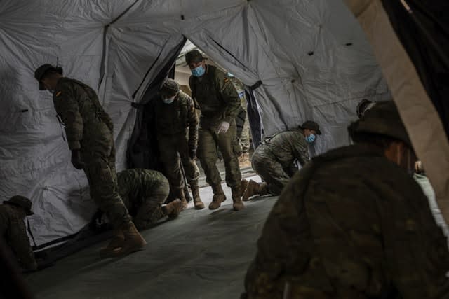 Spanish soldiers erect a tent to be used by patients