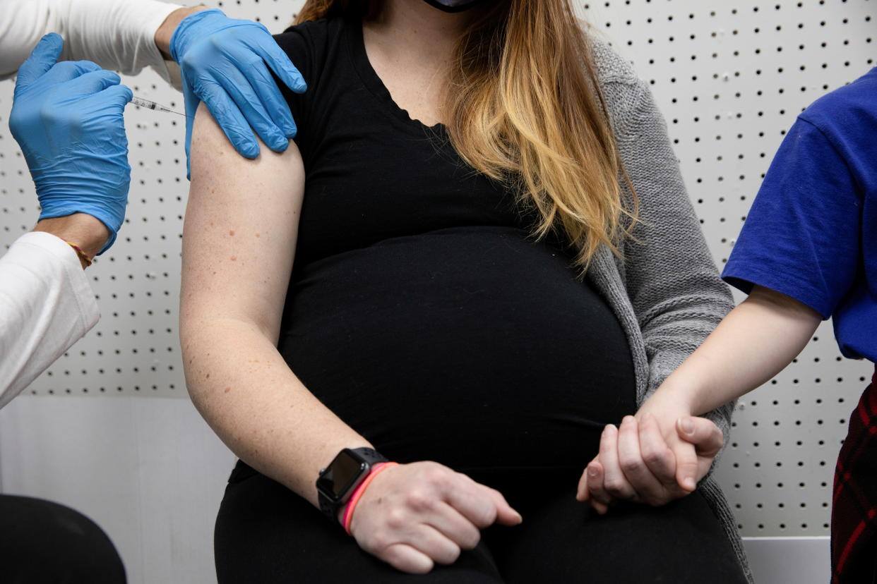 A pregnant woman receives a vaccine for the coronavirus disease (COVID-19) at Skippack Pharmacy in Schwenksville, Pennsylvania, U.S., February 11, 2021.  REUTERS/Hannah Beier     TPX IMAGES OF THE DAY