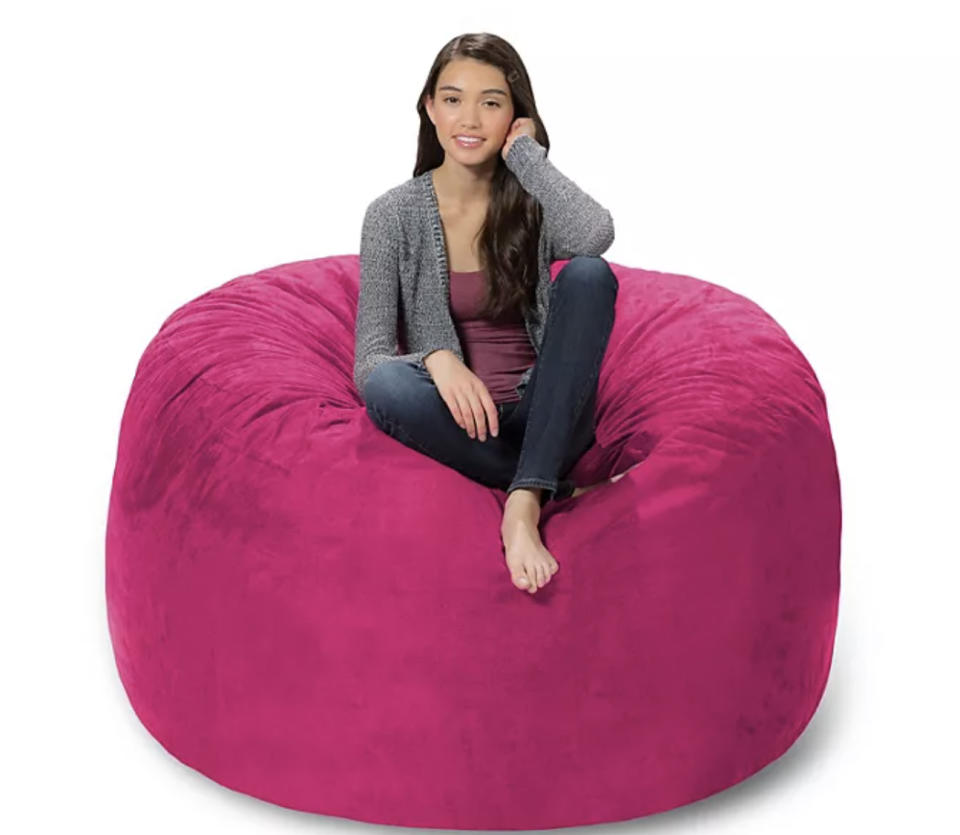 A person sitting on a pink bean bag