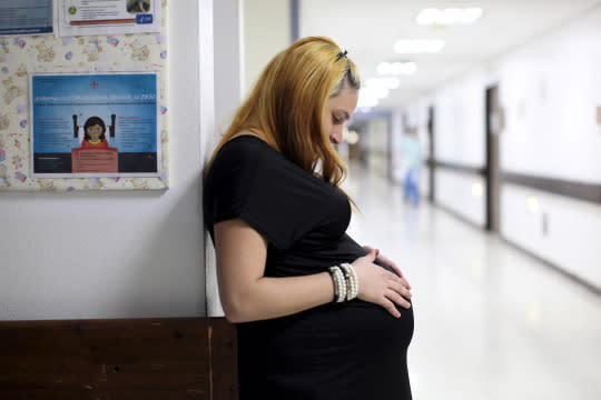 Jannelissa Santana, who is 37 weeks pregnant, leans on a wall, next to a flyer explaining how to prevent Zika, Dengue and Chikungunya viruses at a public hospital in San Juan, Puerto Rico, February 3, 2016. (Alvin Baez/REUTERS) 