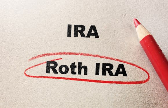 The words IRA and Roth IRA on a piece of paper with a red pencil to the side. Roth IRA is circled in red.