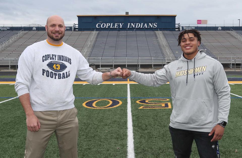 Landon Robinson, right, and Copley High School football head coach Jake Parsons stand on the football field at the school Tuesday, April 20, 2021.