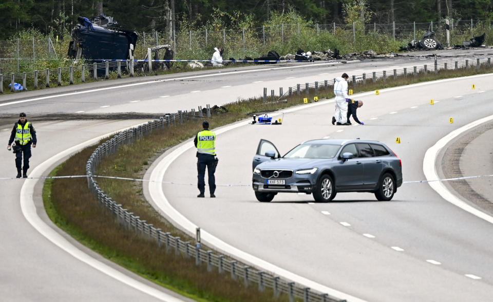 FILE - Forensic technicians work at the scene after a traffic accident between a car and a lorry outside the town Markaryd in Sweden, Monday Oct. 4, 2021. Swedish authorities say an exploding tire led the driver of the unmarked police car carrying Swedish artist Lars Vilks to lose control last year and crash head-on with a truck. The Oct 4 crash killed three people, including the 75-year-old cartoonist. Vilks had faced death threats and lived under police protection since his controversial 2007 sketch of the Prophet Muhammad. (Johan Nilsson/TT News Agency via AP, File)