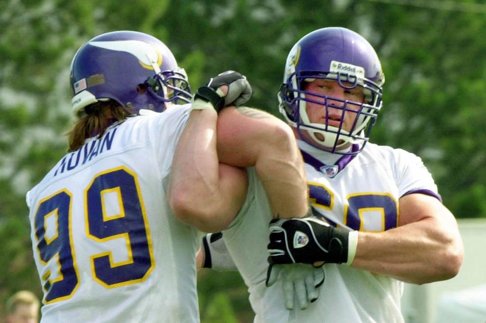 Minnesota Vikings' Chris Hovan, left, shares some technique pointers with former professional wrestler Brock Lesnar, right, during workouts Saturday, July 31, 2004, in Mankato, Minn., where Lesnar is hoping to start a new career in professional football. Lesnar last played football in high school but not college. (AP Photo/Jim Mone) ORG XMIT: MNJM102