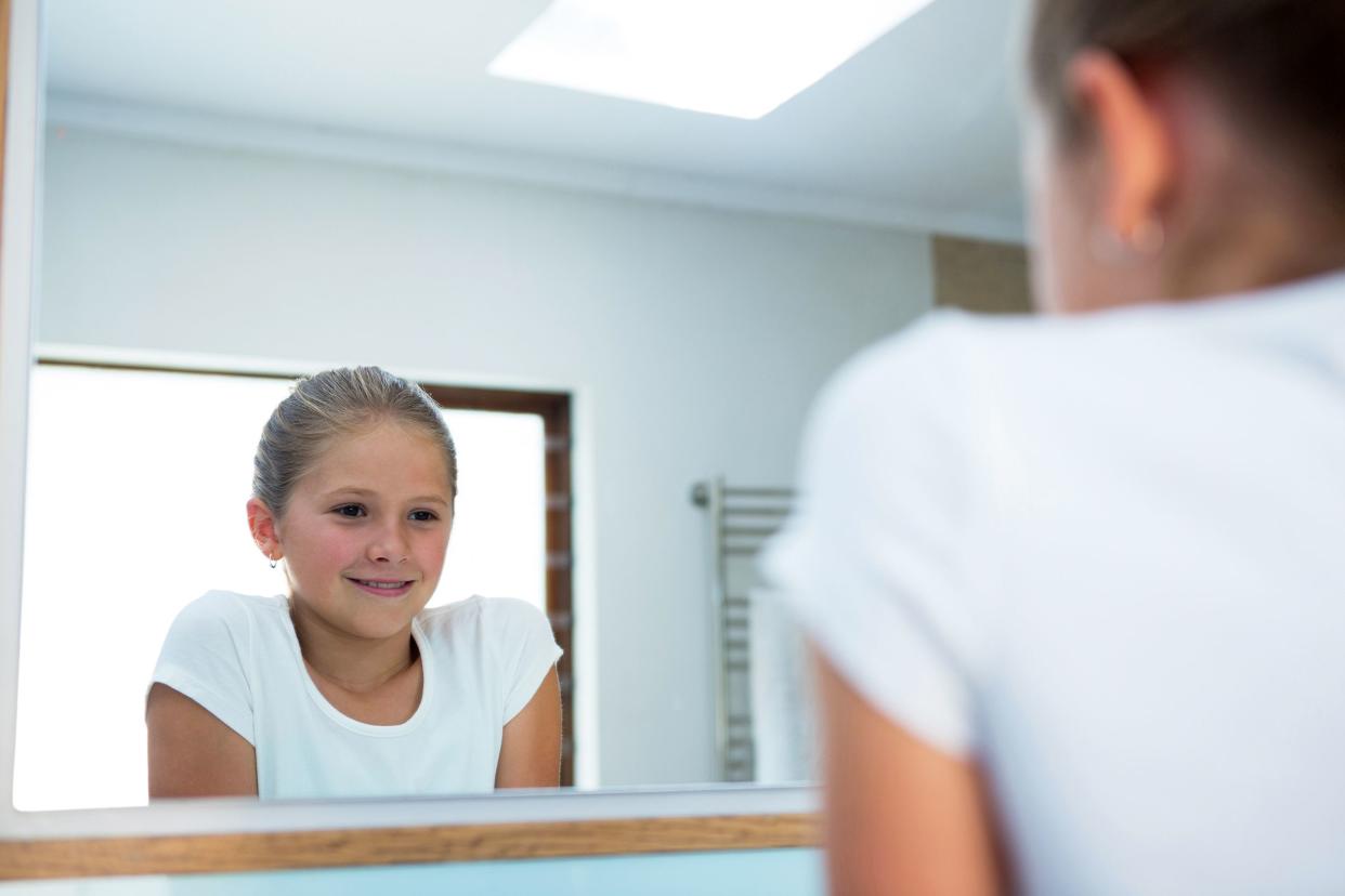 Girl talking to herself in the mirror