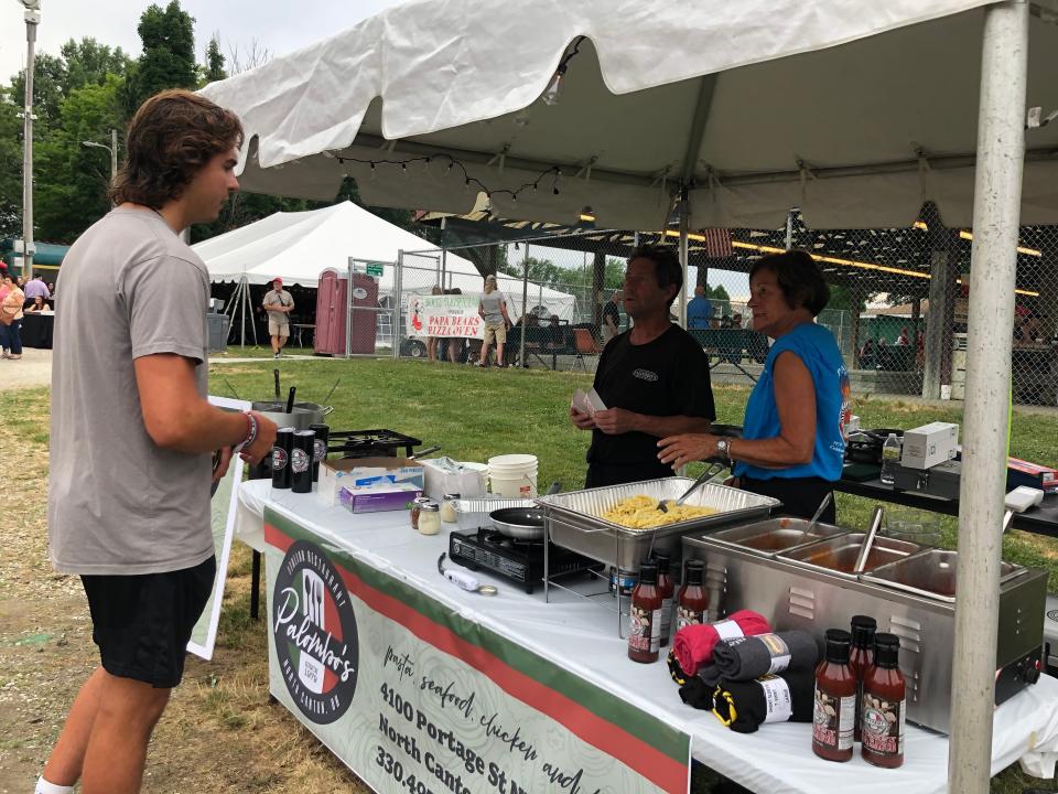 Rick Palombo and Maria Elum of Palombo's Italian Restaurant talk to a attendee of the Stark County Italian-American festival Friday night at Weis Park in Canton.